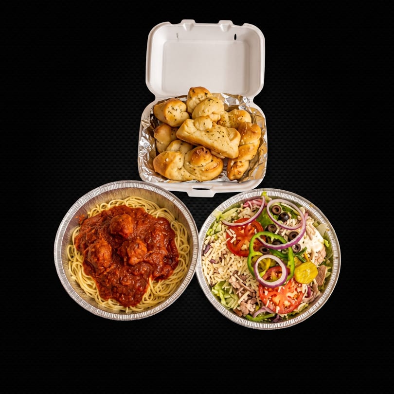 Spaghetti with meatballs, a large salad, and garlic knots in takeout containers.